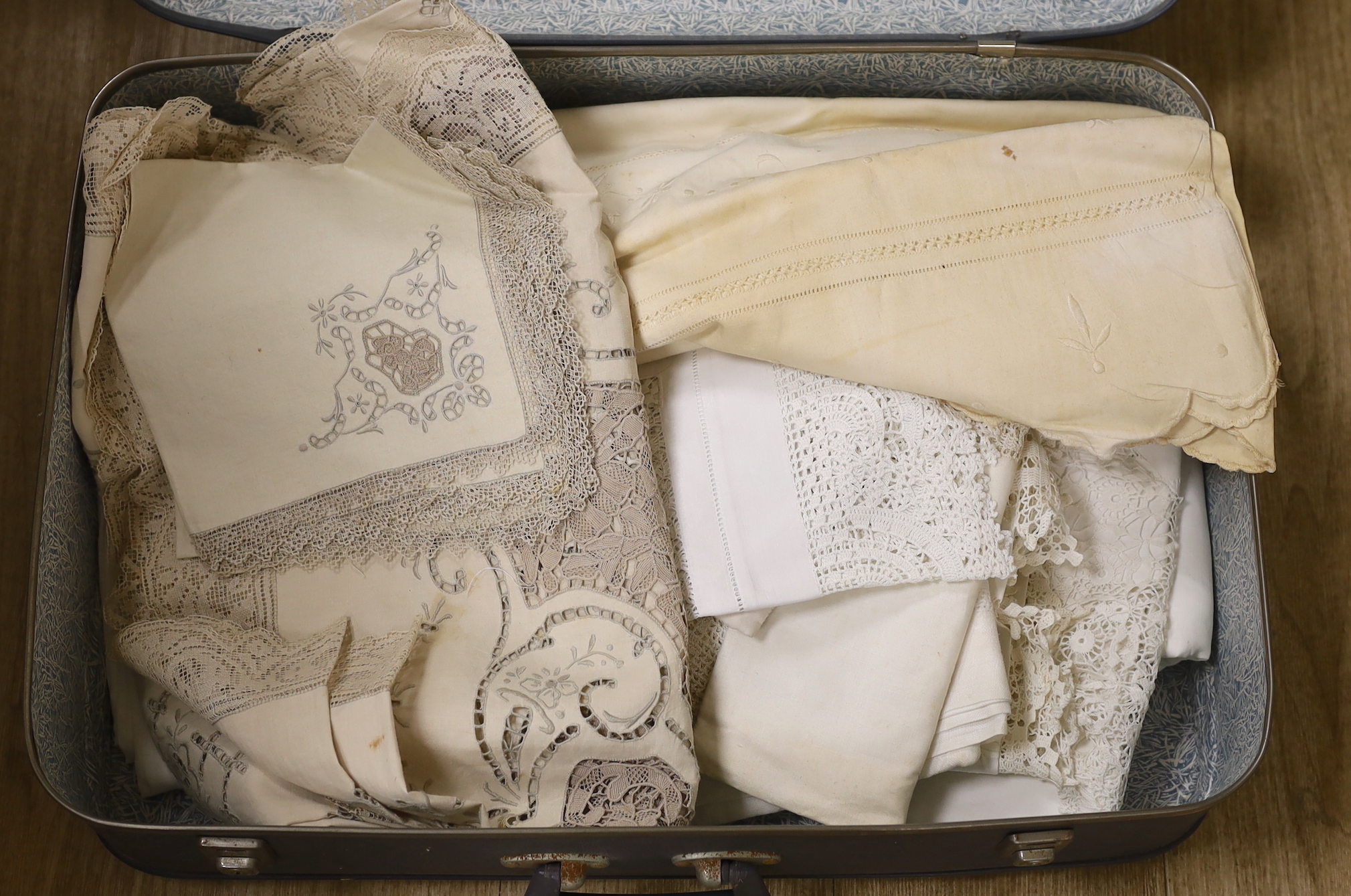 An embroidered linen sheet, a collection of crochet edged table cloths and an embroidered Madeira cloth and matching napkins